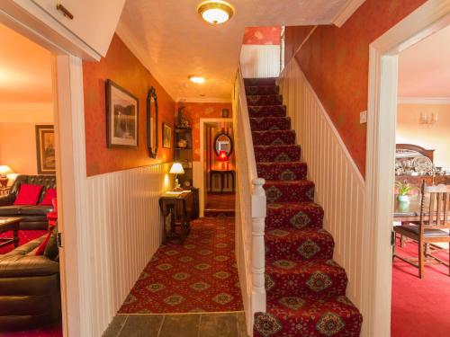 a stairway in a home with a red wall at Murphys Farmhouse B&B in Castlemaine