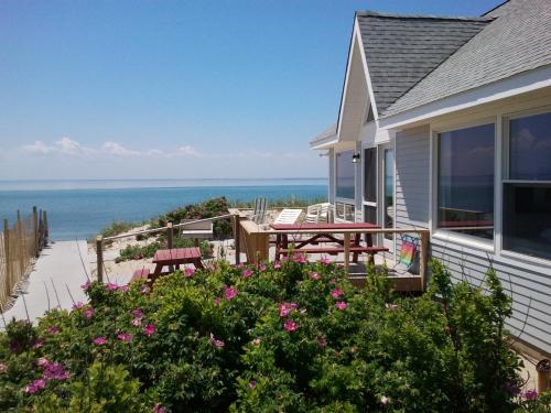 a house with a balcony with a view of the ocean at Horizons Beach Resort in North Truro
