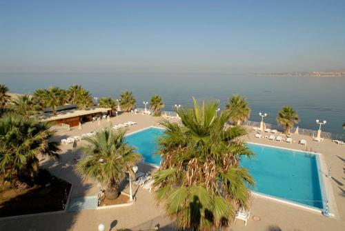 an aerial view of a resort with a pool and palm trees at Dioscuri Bay Palace in San Leone