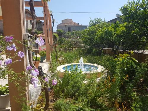 a garden with a fountain in the middle at Apartments and Rooms Dobrila in Jelsa