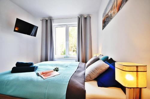 コウォブジェクにあるApartament Lazur Polanki Parkのベッドルーム1室(青いベッド1台、窓付)