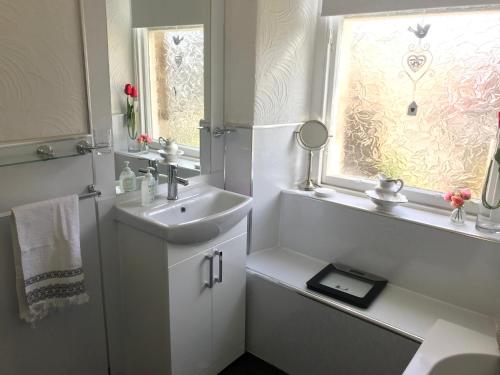 a white bathroom with a sink and a window at 233 Leith Apartment in Edinburgh