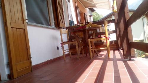 a room with a table and chairs on a porch at Holiday home Désirée in Sorico