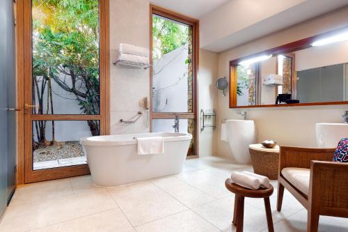 a bathroom with a large tub and a window at Melia Zanzibar in Kiwengwa