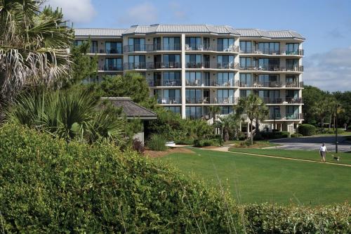 a man playing golf in front of a resort at Litchfield Beach & Golf Resort in Pawleys Island