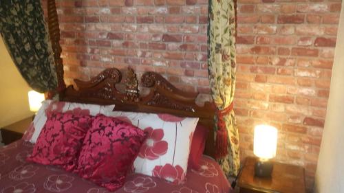 a bedroom with a brick wall and a bed at Angel Guesthouse in Tiverton