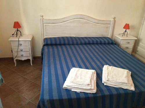 1 dormitorio con 1 cama con toallas en Residenza Rosmarini, en Palau