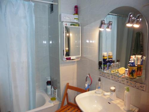 ein Badezimmer mit einem Waschbecken, einer Badewanne und einem Spiegel in der Unterkunft Apartament jofre in Sant Feliu de Guixols
