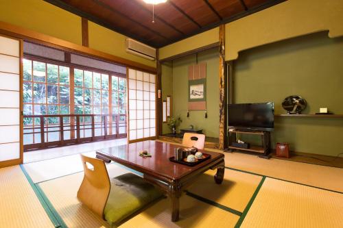 sala de estar con mesa y TV en Ryokan Dangoya, en Kamiichi