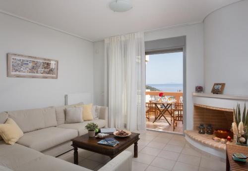 een witte woonkamer met een bank en een tafel bij Comfortable house with amazing view in Anavissos