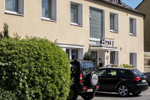 een zwarte auto geparkeerd voor een hotel bij Hotel Alscher in Leverkusen