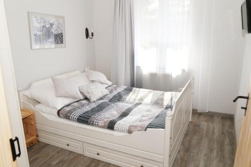 a white bed in a room with a window at 4 STRONY ŚWIATA Dom Gościnny in Dźwirzyno