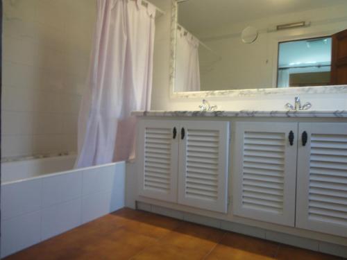 y baño con 2 lavabos, espejo y bañera. en Villa palenque en Santa Cristina d'Aro