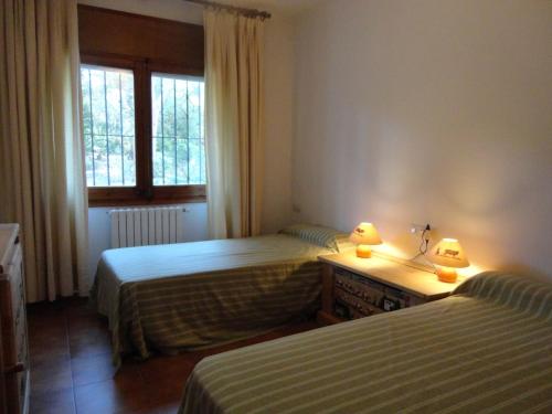 1 dormitorio con 2 camas y 2 lámparas en un escritorio en Villa palenque, en Santa Cristina d'Aro