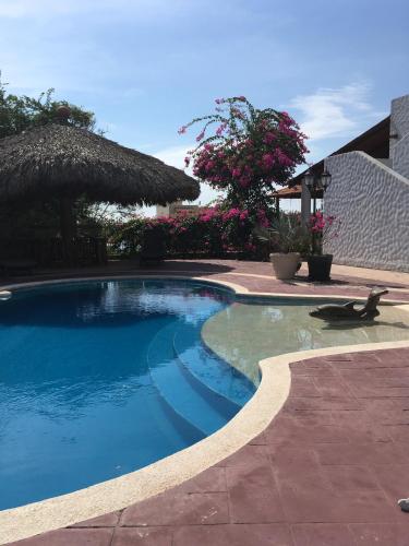 a swimming pool next to a building with a resort at Loft on the Pacific in La Union de Isidoro Montes de Oca