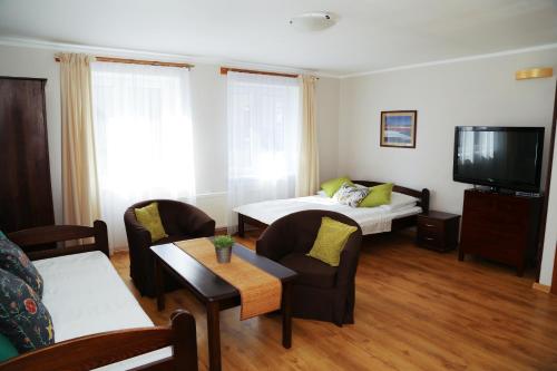 a living room with a bed and a tv at 4 STRONY ŚWIATA Pokoje i Apartamenty in Dźwirzyno