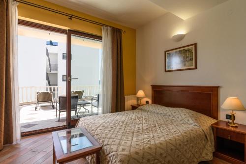 1 dormitorio con 1 cama y balcón en Villa Lavandula with heated swimming pool, en Trogir