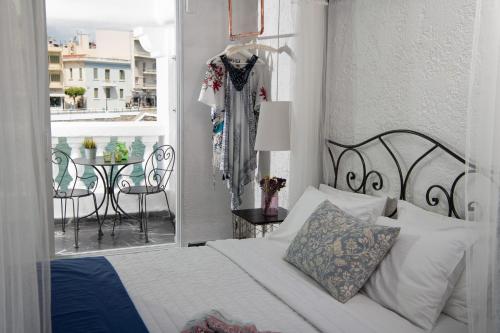 a bedroom with a bed and a balcony with a table at Porto Maltese Boutique Estate in Agios Nikolaos