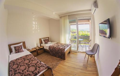 a hotel room with two beds and a balcony at Amal Grand Villa in Bihać