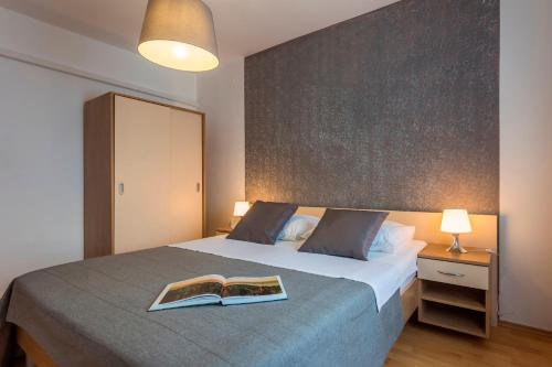 a bedroom with a bed with a book on it at Apartments Rajkovic in Labin