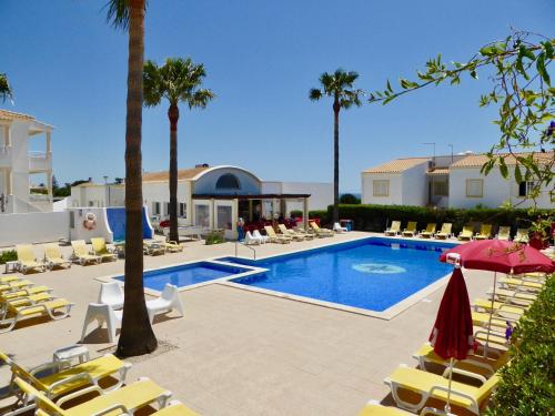 a swimming pool with lounge chairs and a resort at Vela by Check-in Portugal in Albufeira