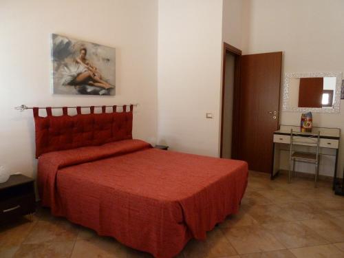 a bedroom with a red bed in a room at Sole in San Vito lo Capo