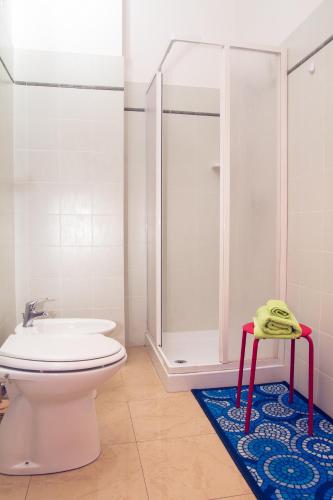 a bathroom with a shower and a toilet and a rug at Casa Stoccolma in Pozzallo