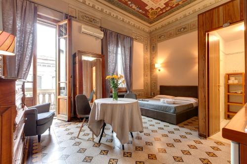 フィレンツェにあるSleep Tight Florence Apartmentのテーブルとベッドが備わるホテルルームです。
