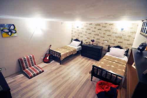 ein Zimmer mit 2 Betten und einem Stuhl darin in der Unterkunft Mia's Apartment in Tbilisi City