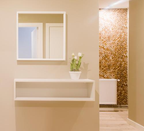 a bathroom with a mirror and a vase with flowers at Rio Sil Carballo in Carballo