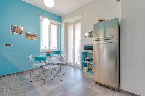 uma cozinha com um frigorífico e uma mesa com cadeiras em Torino Comodo Al Centro em Turim