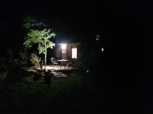 a house at night with a table in the yard at La cabane de Pioupiou in Fayence