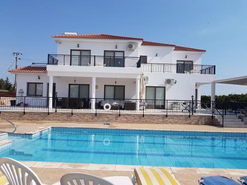 a villa with a swimming pool in front of a house at Nayia Paradise Villa! Best Villa in Cyprus in Paphos City