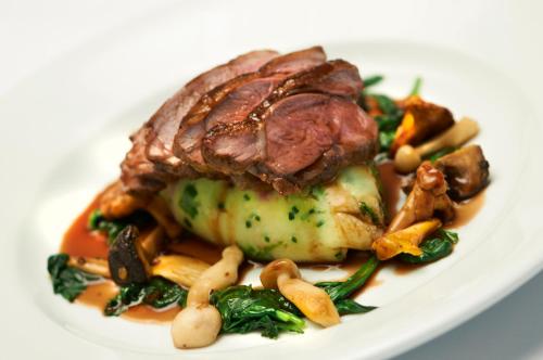 a plate of food with a piece of meat and vegetables at The Museum Inn in Farnham
