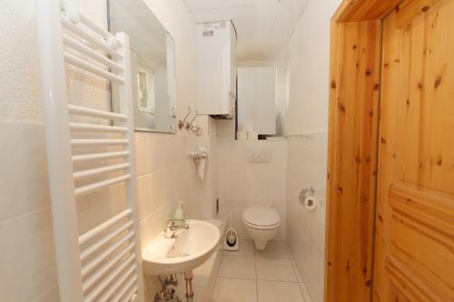 a white bathroom with a sink and a toilet at Klosterherberge in Meßkirch