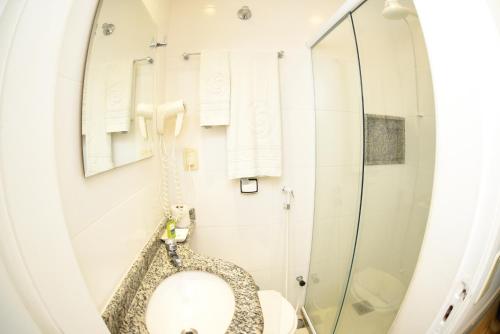 a bathroom with a toilet and a shower at Hotel Village Icaraí in Niterói