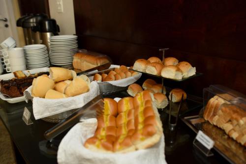 a buffet with various types of bread and pastries at Hotel Village Icaraí in Niterói