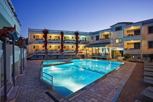 a large swimming pool in front of a building at Ariadne Hotel in Platanes