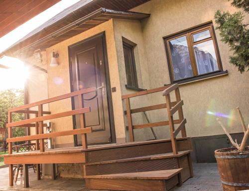 a house with a wooden staircase next to a door at Domek w Dąbrowie in Wielogłowy