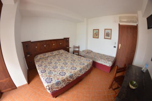 1 dormitorio pequeño con 2 camas y mesa en La Locandiera affittacamere, en Scilla