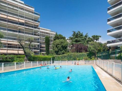 un groupe de personnes se baignant dans une grande piscine dans l'établissement Le Corinthe studio apartment, à Antibes