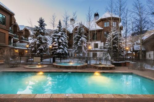 a swimming pool in front of a building with snow covered trees at The Residences at Mountain Lodge by Hyatt Vacation Club in Beaver Creek