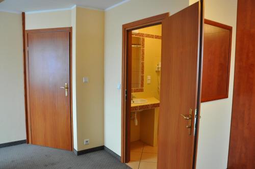 baño con 2 puertas, lavabo y espejo en Villa Mirage, en Łeba