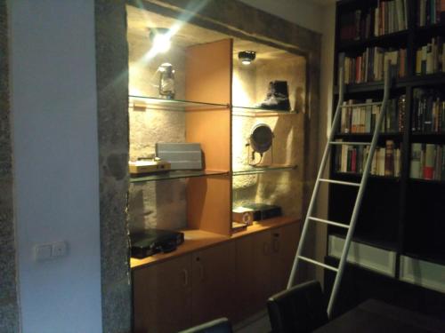 una habitación con una estantería de libros y una escalera en Fogar de Breogan, en Santiago de Compostela