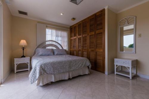 a bedroom with a bed and a window and a mirror at King David Suites in Palm-Eagle Beach