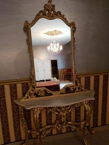 an ornate mirror on a table in a room at NF Palace Old City Bucharest in Bucharest