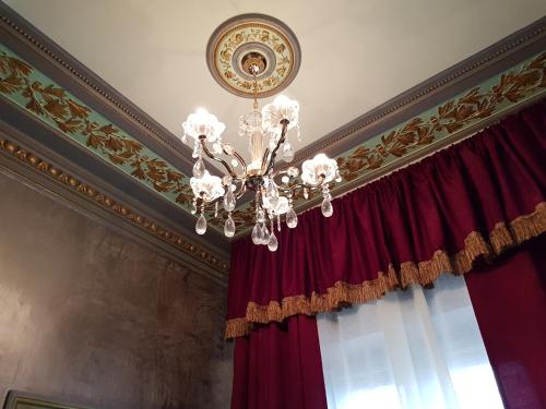 a chandelier in a room with red curtains at NF Palace Old City Bucharest in Bucharest