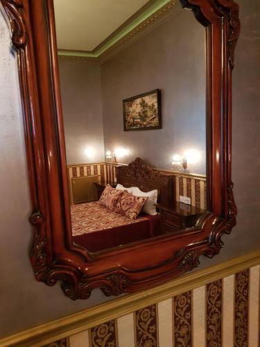 a bedroom with a large mirror on the wall at NF Palace Old City Bucharest in Bucharest