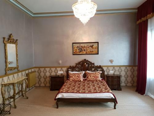 a bedroom with a bed and a chandelier at NF Palace Old City Bucharest in Bucharest