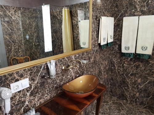 a bathroom with a bowl sink and a mirror at NF Palace Old City Bucharest in Bucharest